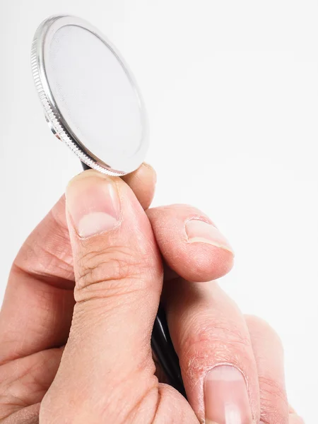 Closeup of hand holding a stethoscope towards bright background — Stock Photo, Image