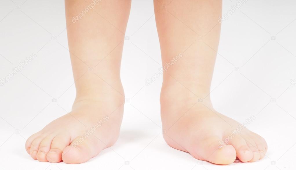 Little person standing up barefoot towards bright background