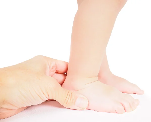 Male hand holding firmly around a foot of toddler isolated on wh — Stock Photo, Image