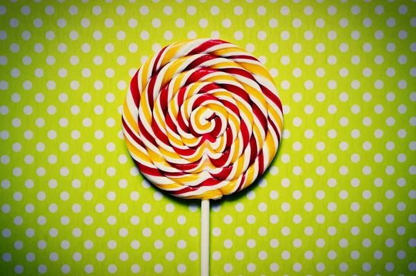 Lollipop on a green polka dot background — Stock Photo, Image