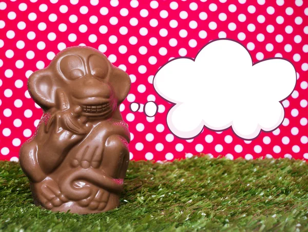 Шоколадная обезьяна на траве — стоковое фото