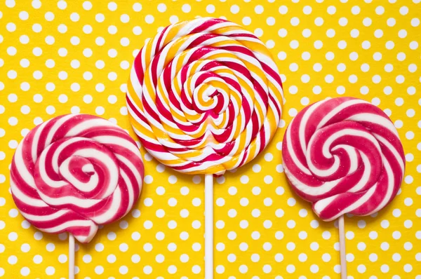 Lollipops on a yellow polka dot background — Stock Photo, Image