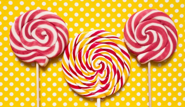 Lollipops on a yellow polka dot background — Stock Photo, Image