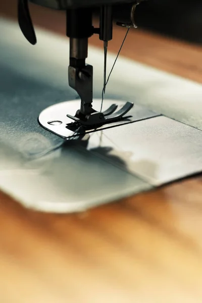 Aydınlatılmış çalışma alanına sahip bir dikiş makinesinin yakın çekimi