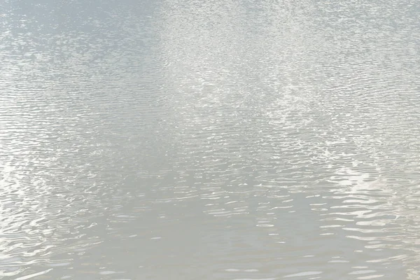 Reflection of light on a water surface in neutral gray tones