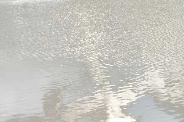 Reflection of light on a water surface in neutral gray tones