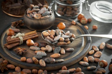 Eskimiş bir arka planda kakao çekirdeği ve fındıklı siyah çikolata..