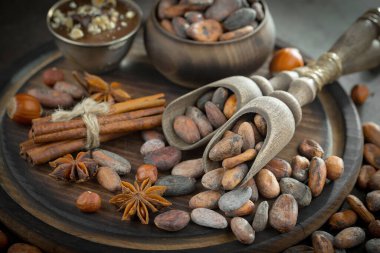 Eskimiş bir arka planda kakao çekirdeği ve fındıklı siyah çikolata..