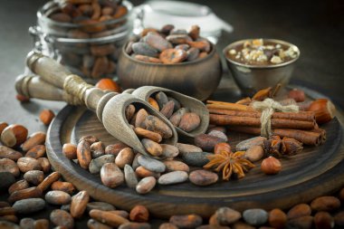 Eskimiş bir arka planda kakao çekirdeği ve fındıklı siyah çikolata..