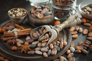 Eskimiş bir arka planda kakao çekirdeği ve fındıklı siyah çikolata..