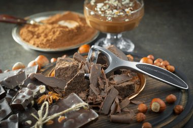 Eskimiş bir arka planda kakao çekirdeği ve fındıklı siyah çikolata..