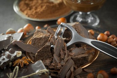 Eskimiş bir arka planda kakao çekirdeği ve fındıklı siyah çikolata..