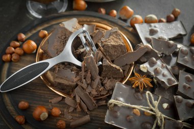 Eskimiş bir arka planda kakao çekirdeği ve fındıklı siyah çikolata..