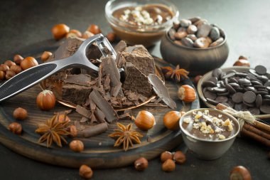 Eskimiş bir arka planda kakao çekirdeği ve fındıklı siyah çikolata..