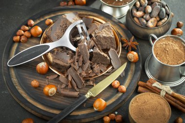 Eskimiş bir arka planda kakao çekirdeği ve fındıklı siyah çikolata..