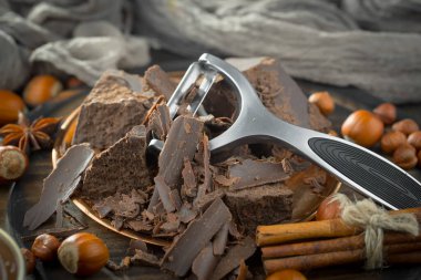 Eskimiş bir arka planda kakao çekirdeği ve fındıklı siyah çikolata..