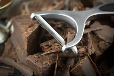 Eskimiş bir arka planda kakao çekirdeği ve fındıklı siyah çikolata..