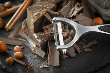 Eskimiş bir arka planda kakao çekirdeği ve fındıklı siyah çikolata..