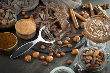 Eskimiş bir arka planda kakao çekirdeği ve fındıklı siyah çikolata..