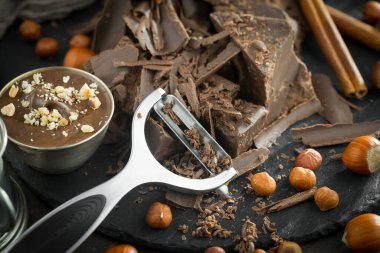 Eskimiş bir arka planda kakao çekirdeği ve fındıklı siyah çikolata..