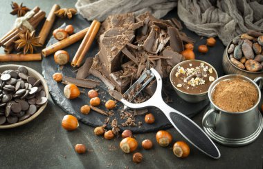 Eskimiş bir arka planda kakao çekirdeği ve fındıklı siyah çikolata..