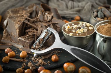 Eskimiş bir arka planda kakao çekirdeği ve fındıklı siyah çikolata..