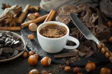 Eskimiş bir arka planda kakao çekirdeği ve fındıklı siyah çikolata..