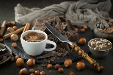 Eskimiş bir arka planda kakao çekirdeği ve fındıklı siyah çikolata..