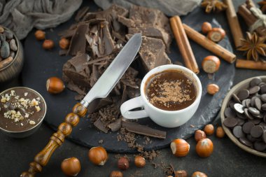 Eskimiş bir arka planda kakao çekirdeği ve fındıklı siyah çikolata..