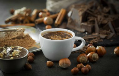 Eskimiş bir arka planda kakao çekirdeği ve fındıklı siyah çikolata..