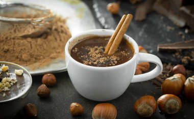 Eskimiş bir arka planda kakao çekirdeği ve fındıklı siyah çikolata..