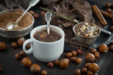 Eskimiş bir arka planda kakao çekirdeği ve fındıklı siyah çikolata..