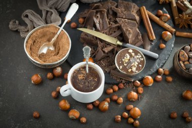 Eskimiş bir arka planda kakao çekirdeği ve fındıklı siyah çikolata..