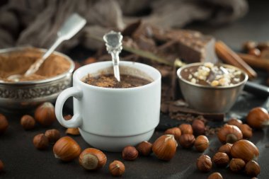 Eskimiş bir arka planda kakao çekirdeği ve fındıklı siyah çikolata..