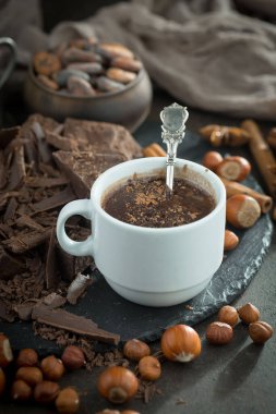 Eskimiş bir arka planda kakao çekirdeği ve fındıklı siyah çikolata..