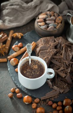 Eskimiş bir arka planda kakao çekirdeği ve fındıklı siyah çikolata..