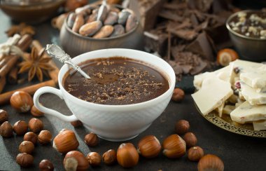 Eskimiş bir arka planda kakao çekirdeği ve fındıklı siyah çikolata..