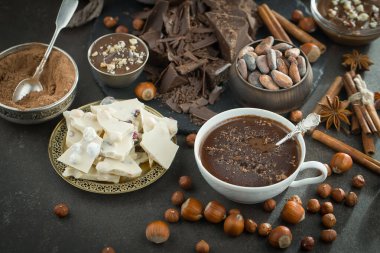 Eskimiş bir arka planda kakao çekirdeği ve fındıklı siyah çikolata..