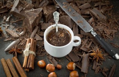 Eskimiş bir arka planda kakao çekirdeği ve fındıklı siyah çikolata..