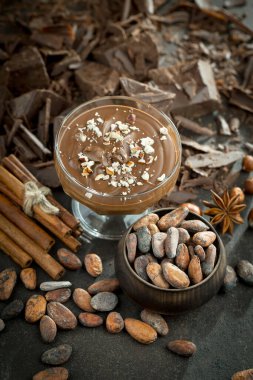 Eskimiş bir arka planda kakao çekirdeği ve fındıklı siyah çikolata..