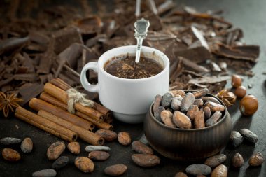 Eskimiş bir arka planda kakao çekirdeği ve fındıklı siyah çikolata..