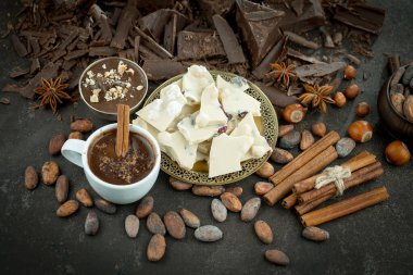Eskimiş bir arka planda kakao çekirdeği ve fındıklı siyah çikolata..