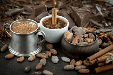 Eskimiş bir arka planda kakao çekirdeği ve fındıklı siyah çikolata..