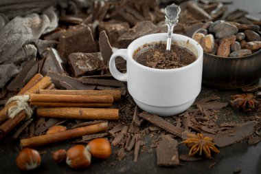 Eskimiş bir arka planda kakao çekirdeği ve fındıklı siyah çikolata..