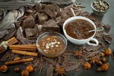 Eskimiş bir arka planda kakao çekirdeği ve fındıklı siyah çikolata..