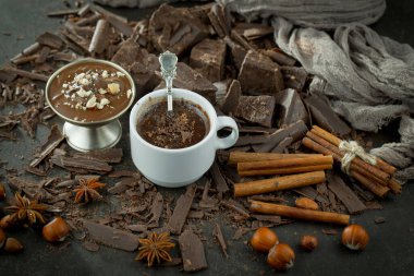 Eskimiş bir arka planda kakao çekirdeği ve fındıklı siyah çikolata..