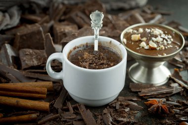 Eskimiş bir arka planda kakao çekirdeği ve fındıklı siyah çikolata..