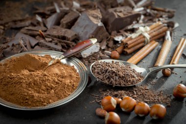 Eskimiş bir arka planda kakao çekirdeği ve fındıklı siyah çikolata..