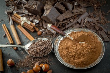 Eskimiş bir arka planda kakao çekirdeği ve fındıklı siyah çikolata..