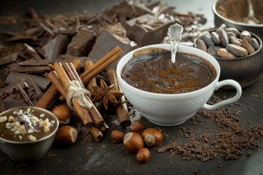 Eskimiş bir arka planda kakao çekirdeği ve fındıklı siyah çikolata..